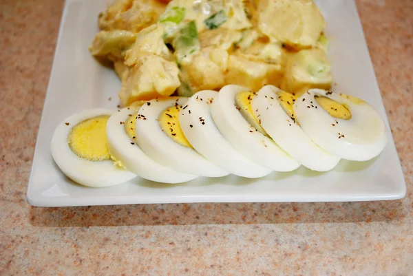 Geschnittenes Ei mit Kartoffelsalat im Hintergrund — Stockfoto