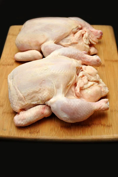Due polli da friggitrice crudi su un tagliere di legno — Foto Stock