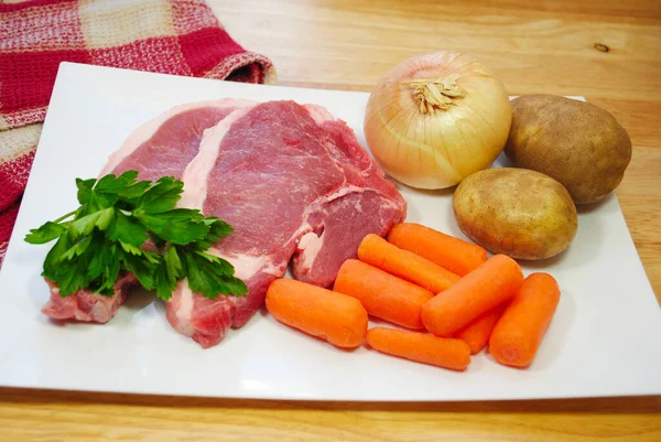 Een Rauwe Maaltijd Van Verse Varkenskoteletjes Babywortelen Aardappelen — Stockfoto