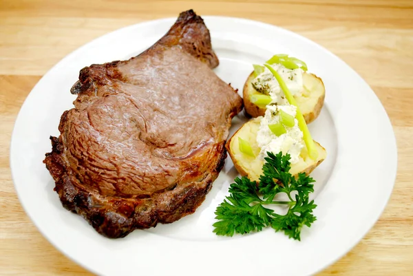 Ein Gebratenes Prime Rib Steak Serviert Mit Ofenkartoffeln Und Schalotten — Stockfoto