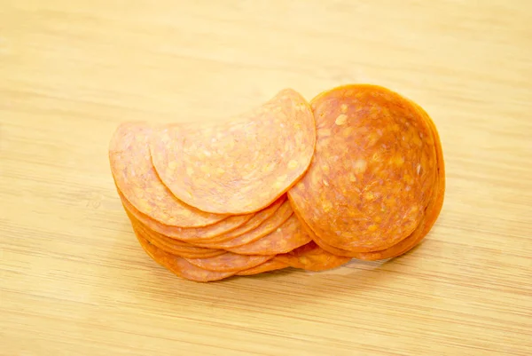 Aufgeschnittene Pepperoni Auf Einer Hölzernen Oberfläche Gehäuft — Stockfoto