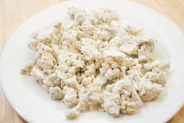 Moldy Crumbled Blue Cheese Uma Placa Branca — Fotografia de Stock