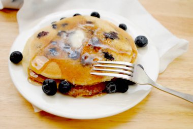 Tereyağı ve şurupla kaplı yaban mersinli krep yemek.