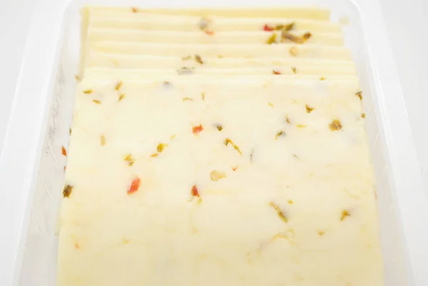 白の背景に隔離されたペッパージャックチーズスライス — ストック写真