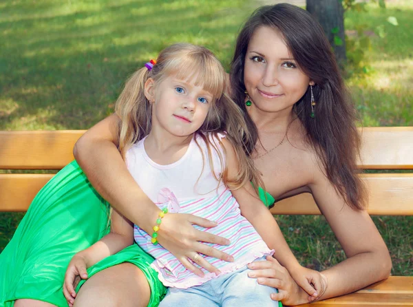 Mãe e filha sentadas no banco — Fotografia de Stock