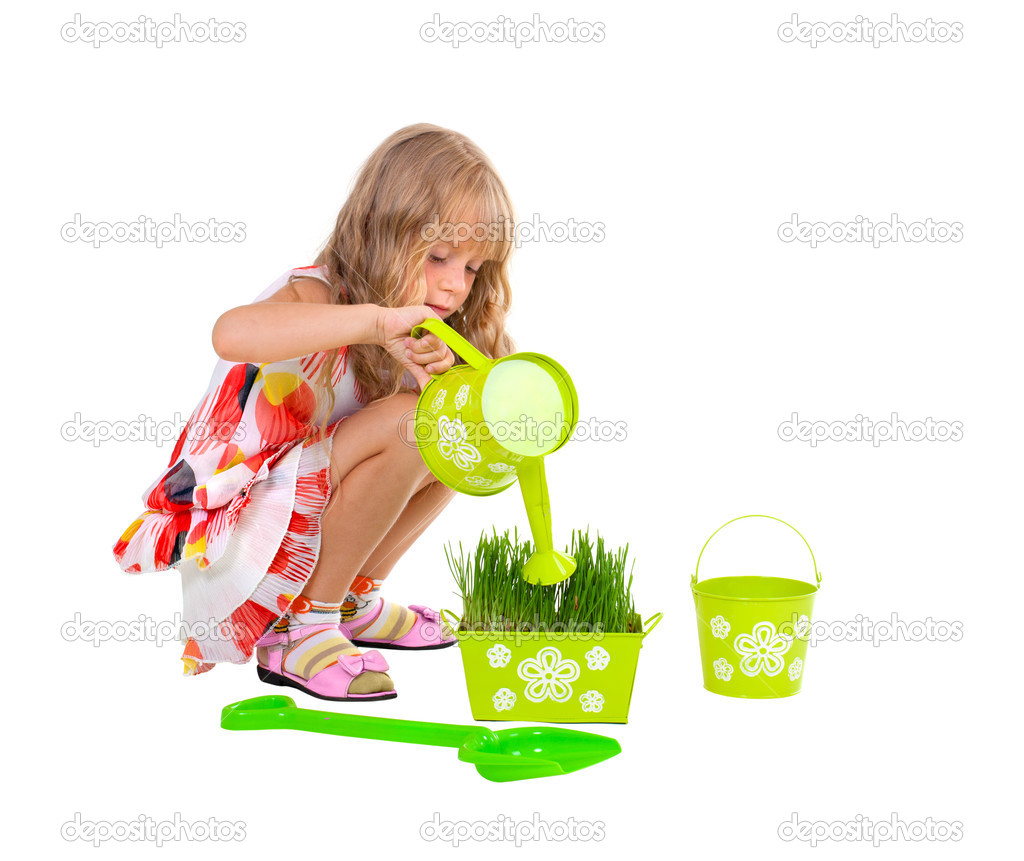 Little girl watering grass isolated on white background