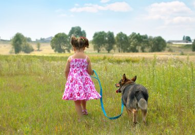 çayır adlı Köpeğiyle yürüyen ve köpek tasmasını tutan küçük kız