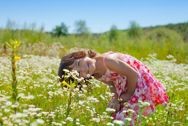 Menina feliz brincando no campo de flores — Fotografia de Stock