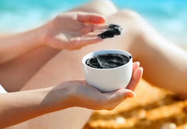 Woman smearing mud mask on the body — Stock Photo, Image