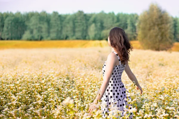 Jeune fille heureuse marchant sur le champ de sarrasin — Photo