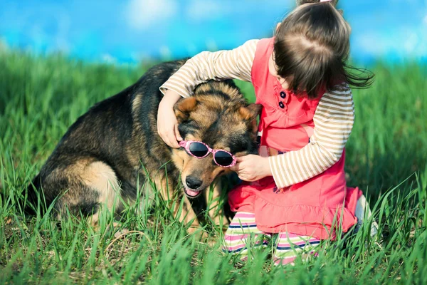 Ragazzina che si mette gli occhiali da sole sul cane — Foto Stock