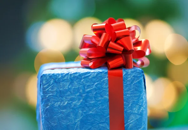 Un regalo azul con una cinta roja en Navidad — Foto de Stock