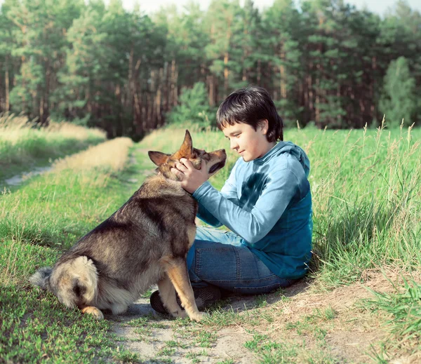 Мальчик сидит со своей собакой на треке — стоковое фото