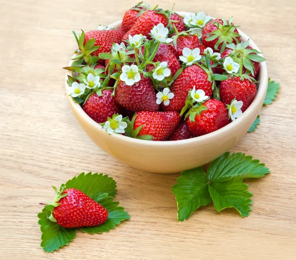 Fresas en un tazón sobre mesa de madera — Foto de Stock