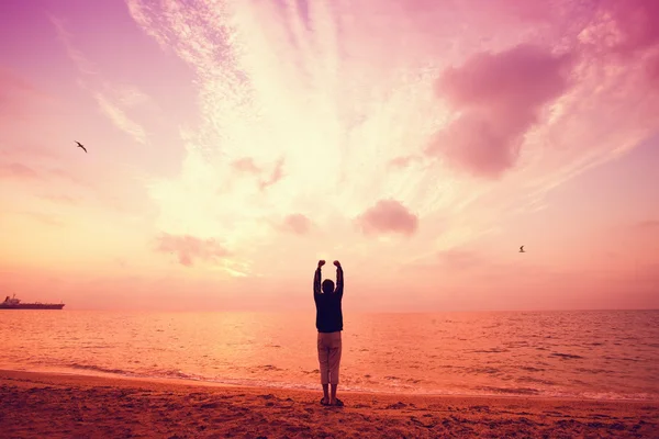 Silhueta do homem levantou as mãos para o céu ao pôr do sol — Fotografia de Stock