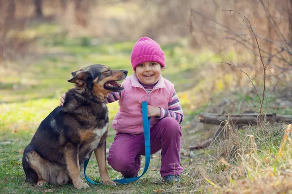 Dziewczynka z pies w lesie — Zdjęcie stockowe