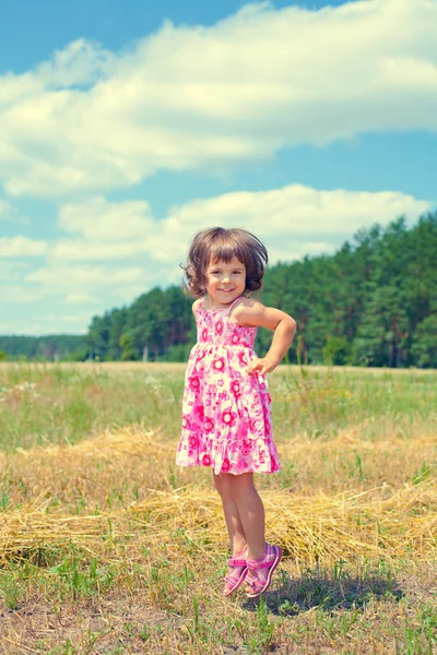 Happy little girl jumping in the meadow — Stock Photo, Image