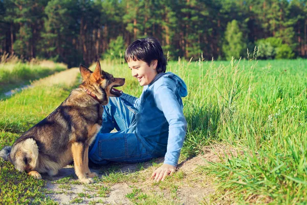 Garçon avec son chien sur la prairie — Photo