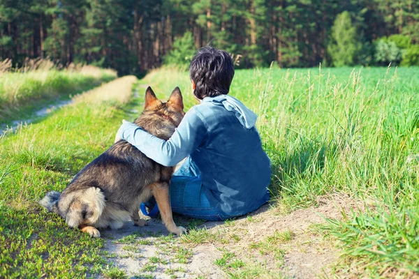 Junge sitzt mit Hund auf der Wiese — Stockfoto