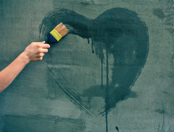 Femme peinture à la main coeur sur le mur de béton — Photo