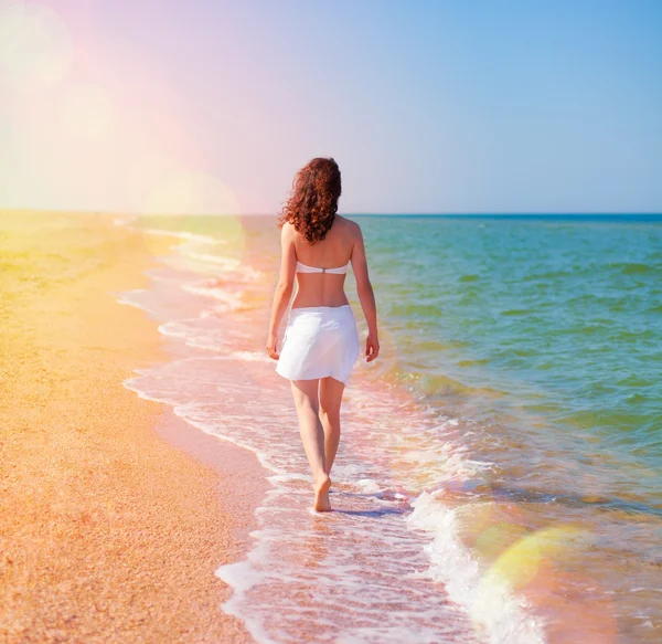 Ung kvinna promenader på stranden — Stockfoto