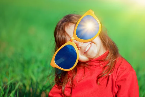 Büyük güneş gözlüğü ile mutlu küçük kız — Stok fotoğraf