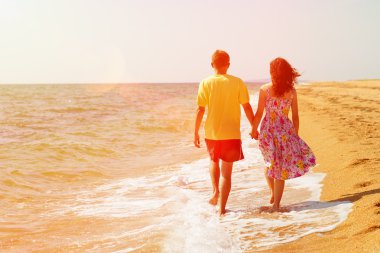 Kumsalda yürüyen çift.