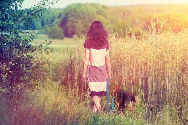 Jovem mulher caminhando com cão — Fotografia de Stock