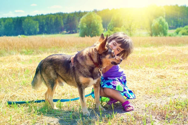 Счастливая маленькая девочка играет с собакой — стоковое фото