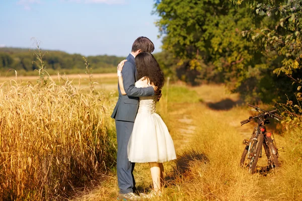 Paar umarmt sich über Weizenfeld — Stockfoto