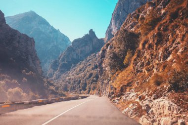 Güneşli bir günde güzel bir dağ manzarasının ön camdan görünüşü. Picos de Europa Ulusal Parkı 'ndaki dağlık viraj yolunda araba kullanmak. Cantabria, İspanya, Avrupa