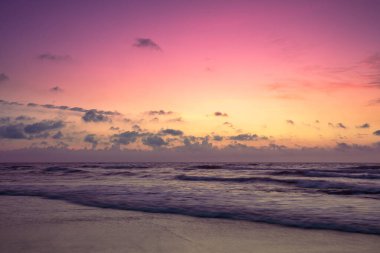 Sabahın erken saatlerinde deniz manzarası. Güzel gökyüzü olan kumlu bir sahilde gün doğumu