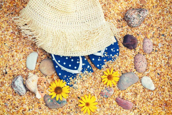 海滩场景 阳光下的草帽 翻动的拖鞋 和太阳镜躺在海滩上的贝壳上 旅行概念 — 图库照片
