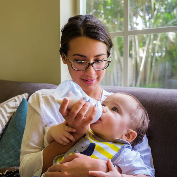 Genç ve güzel bir kadın tarafından beslenen bir bebek — Stok fotoğraf