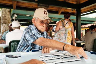 Miami, Florida ABD - 18 Haziran 2022: Popüler Little Havana 'daki tarihi Domino Parkı' nda kimliği belirsiz yaşlı adam domino oyunu oynuyor.