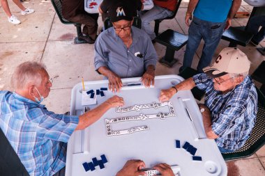 Miami, Florida ABD - 18 Haziran 2022: Popüler Little Havana 'daki tarihi Domino Parkı' nda kimliği belirsiz yaşlılar domino oyunu oynuyorlar.