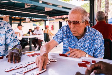 Miami, Florida ABD - 18 Haziran 2022: Popüler Little Havana 'daki tarihi Domino Parkı' nda kimliği belirsiz yaşlı adam domino oyunu oynuyor.