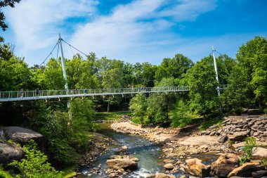 Greenville, South Carolina USA - May 4, 2022: Downtown cityscape view of Falls Park on the Reedy and the Liberty Bridge in this charming southern town.