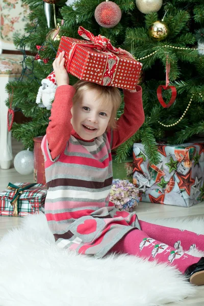 Uma menina recebendo um presente de Natal — Fotografia de Stock