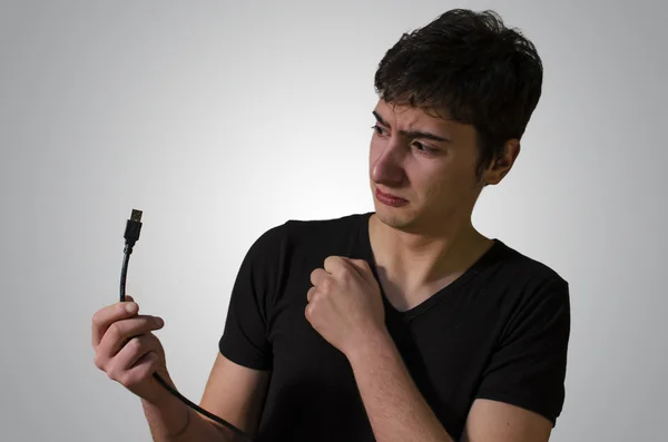 Young Man Arguing with a USB Cable — Stock Photo, Image