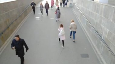 İnsanlar yazın şehirde bir tünele inerler. Kalabalık şehirde yürüyor.