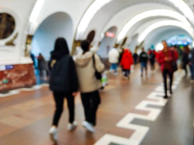 Metro istasyonundaki insanlar koridordan trenlere doğru yürüyorlar.