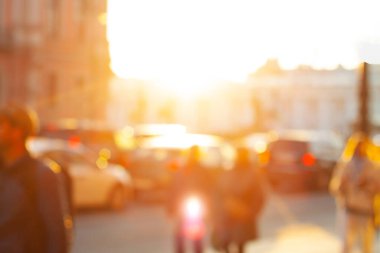 Bulanık arka plan, altın saatinde şehirde yürüyen insanlar. Akşamları bir Avrupa şehrinde seyahat etmek