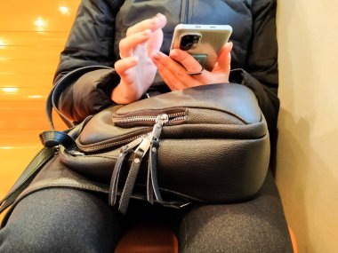 Ulaşım bölümündeki bir kadın akıllı telefondan mesaj yazıyor..