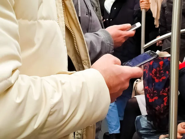 Two People Smartphones Hands Subway Train Going Work — стоковое фото