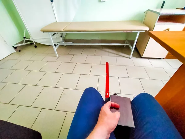 在俄罗斯的一个医务室里 一个年轻人坐在那里等医生 — 图库照片