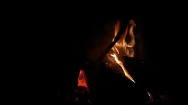 Bir adam sobada yanan odunları değiştiriyor. Kış ısıtma kavramı