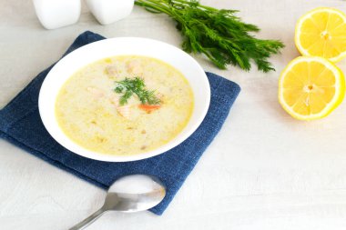 Somon ve kremalı balık çorbası mavi bir peçete üzerinde beyaz bir kase içinde bir demet dereotlu ve limonlu. Lohikeitto geleneksel bir Fince ve Karelya çorbasıdır. Boşluğu kopyala.