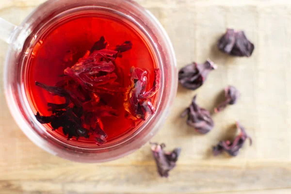 Una Taza Vidrio Con Hibisco Rojo Encuentra Sobre Una Mesa —  Fotos de Stock