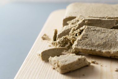 Parçalanmış ayçiçeği halkası gri bir arka planda tahta kesme tahtasının üzerinde yatıyor. Geleneksel doğu tatlıları kavramı. Yatay oryantasyon. Boşluğu kopyala.